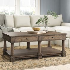 a living room with a couch, coffee table and rug in front of the couch