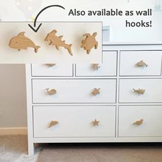 a white dresser with wooden animals on the drawers and an advertisement above it that says also available as wall hooks