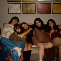 a group of people sitting on top of a couch next to each other in a living room