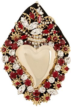 a heart shaped brooch with red and white stones in it's center, surrounded by gold filigrees