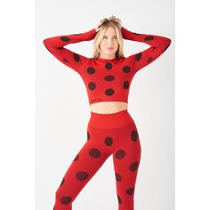 a woman in red and black polka dot tights with her hands on her head