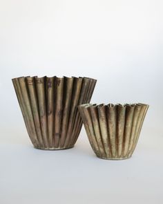 two brown vases sitting next to each other on a white surface