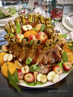 a plate with apples, oranges and other food on it sitting on a table