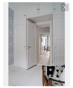 an open door leading into a white room with blue wallpaper on the walls and floor