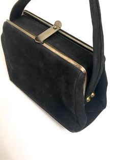 Overview: This classic box purse is sophisticated and elegant! This black velvet bag has a gold tone frame with locking clasp. The interior has a plastic pocket and synthetic lining.  Details:  All measurements taken flat and in inches; Width: 7 at top, 8 at bottom Height: 6 Depth: 3 Good Condition; minor warping and velvet i no longer  The Fine Print: Always a classic, box purses come in many forms. From frame purses to Lucite cases, box purses are a great way to bring mid-century modern sensib Box Purse, Frame Purse, The Fine Print, Top Handle Bags, Fine Print, Velvet Bag, Black Velvet, Purses And Handbags, Top Handle