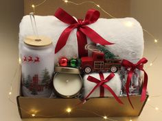 a christmas gift box filled with candles, gifts and other holiday items for someone's special occasion