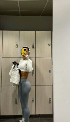 a woman in grey tights and yellow helmet standing next to lockers