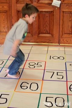 a young boy standing on top of a floor covered in numbers