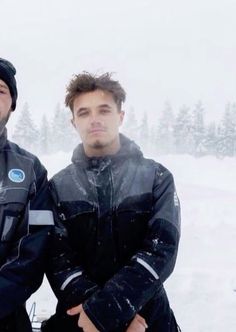 two men standing next to each other in the snow