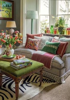 a living room filled with lots of furniture and flowers in vases on the table