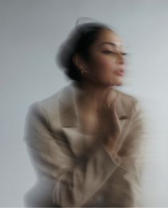 a blurry photo of a woman with her hand on her chin and eyes closed