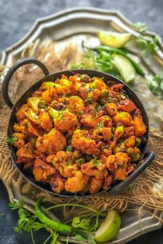 cauliflower and chickpeas in a skillet on a table with other vegetables