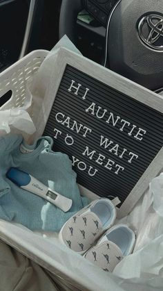 a basket filled with shoes and t - shirts next to a sign that says, hauntie can't wait to meet you