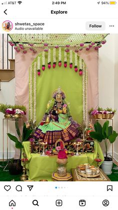 an image of a woman sitting in front of a green stage with flowers on it