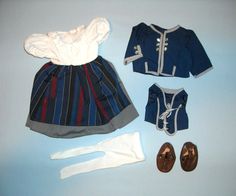 a doll's clothes and shoes are laid out on a blue surface