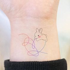 a small tattoo on the ankle of a person's foot with a bunny holding a heart