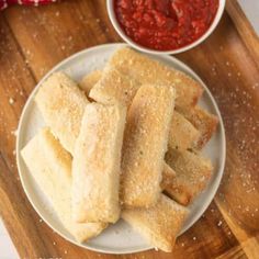 some food is on a white plate and next to a small bowl of red sauce