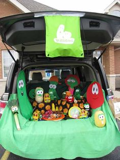 the back end of a car with an open trunk filled with stuffed animals and other items