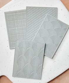 three pieces of tile sitting on top of a table