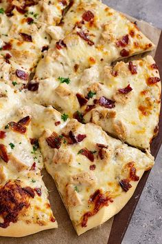 a pizza sitting on top of a cutting board covered in cheese and meat toppings