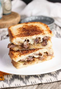 two grilled sandwiches stacked on top of each other with cheese and meat in the middle