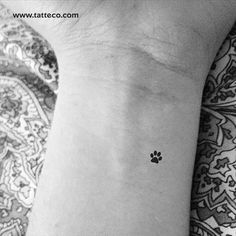 a small dog paw tattoo on the wrist