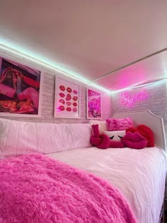 a bedroom with pink lights and pictures on the wall above the bed, along with a white brick wall