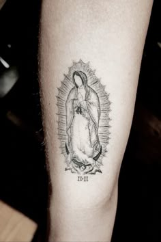 a tattoo on the leg of a person with an image of jesus and baby jesus