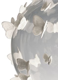 several butterflies are flying in the air above a glass vase with white paint on it