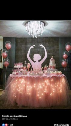 a table topped with pink cake and balloons