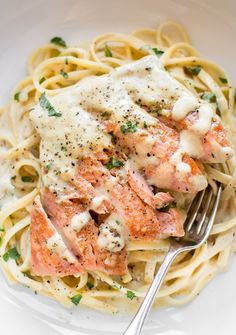 a plate of pasta with salmon and cream sauce