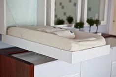 a bed sitting on top of a white dresser