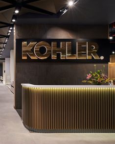 the koller logo is displayed on the wall above the reception counter in this modern office