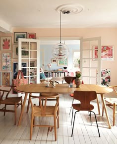 a dining room table with chairs and a chandelier hanging from the ceiling