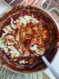 a large pot filled with lots of food on top of a table next to a brick wall