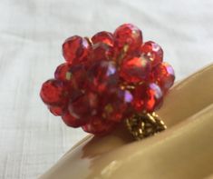 "Red 60s or 70s Big Ring with a band made of gold Stretchy fabric, so it's one size fits all. The ring is basically a 1\" mound of Ruby Red Faceted plastic stones, woven into a shiny red mound. Also, please take a look at my storefront at: https://www.etsy.com/shop/FabFinds42?ref=seller-platform-mcnav I have a wide selection of one-of-a-kind items, from clothing and toys to home decor and gift items, and I add new things almost every day." Round Red Ruby Party Ring, Party Ruby Ring With Round Shape, Handmade Adjustable Red Ruby Ring, Vintage Adjustable Red Ruby Ring, Adjustable Vintage Ruby Ring, Hippie Ring, Stretchy Rings, Shiny Rings, Red Costume