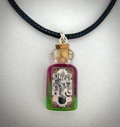 A miniature glass bottle of purple and shimmery green potion with handmade spooky label. On a cotton cord necklace.  Individually handmade. A perfect accessory for a Halloween witch's outfit. Bottle measures 22mm. Note: The corks are glued in place. Do not try to open. Witch's Outfit, Green Potion, Witchs Brew, Cotton Cord Necklace, Witch's Brew, Witch Outfit, Cord Necklace, Cotton Cord, Halloween Witch