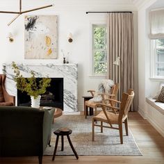 a living room filled with furniture and a fire place in front of a painting on the wall