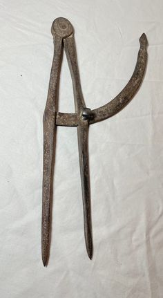 an old pair of scissors sitting on top of a white sheet