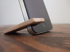 a cell phone with a wooden stick attached to it's back end sitting on a table