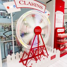 a ferris wheel in the middle of a store with red and white signs on it