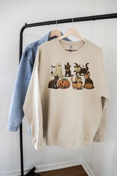 Get ready to embrace the spooky season with our Halloween Cat Sweatshirt! This cozy "Boo Sweatshirt" features adorable cats dressed in their finest Halloween costumes, including playful ghost cats, charming witches, and mischievous pumpkins. Perfect for adding a touch of festive fun to your wardrobe, this Ghost Cat Shirt is a must-have for any cat lover looking to celebrate Halloween in style. Whether you're heading to a party or simply enjoying a cozy night in, our Ghost Sweater will keep you w Casual Halloween Sweatshirt With Cat Design, Halloween Cat Print Crew Neck Sweatshirt, Casual Halloween Sweatshirt With Cat Print, Spooky Cat Design Tops For Fall, Halloween Cat Print Crew Neck Top, Spooky Fall Tops With Cat Print, Spooky Cat Print Tops For Fall, Boo Sweatshirt, Ghost Sweater