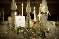 a table topped with candles and glass vases