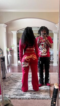 two women standing in front of a mirror