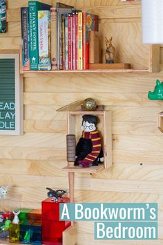 there is a shelf with books on it and a stuffed animal in the box next to it