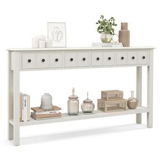 a white console table with drawers and vases