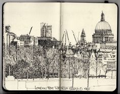 an open sketch book with buildings in the background