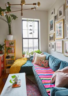 a living room filled with furniture and lots of pictures on the wall next to a window