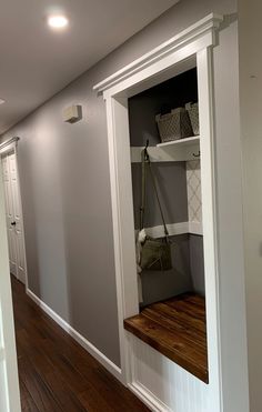 an empty room with some shelves on the wall and wood flooring in front of it