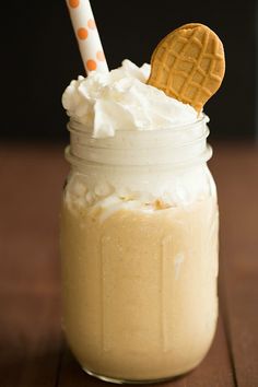 a glass jar filled with whipped cream and a cookie on top